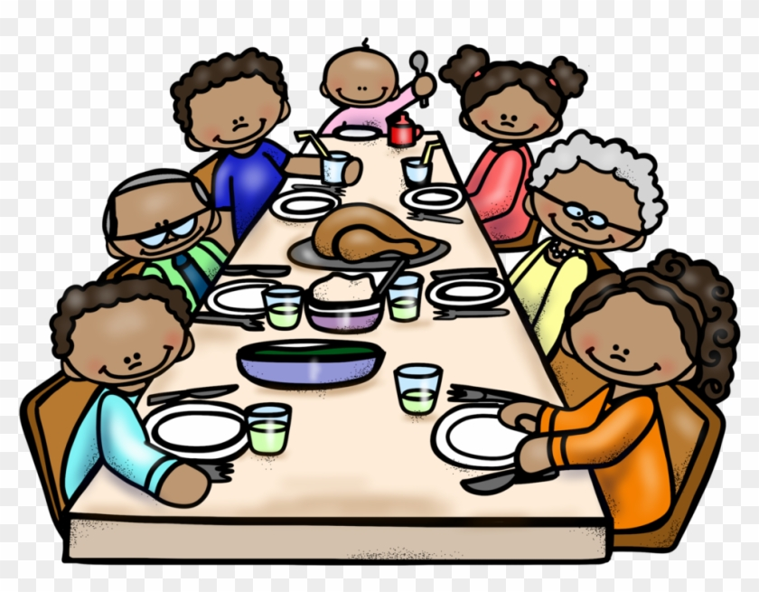 Children and adults sitting at a table for a meal